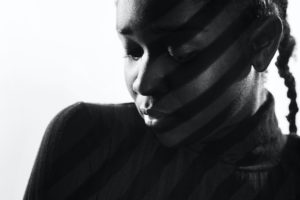 creative stripes from projection light on beautiful woman with dark skin
